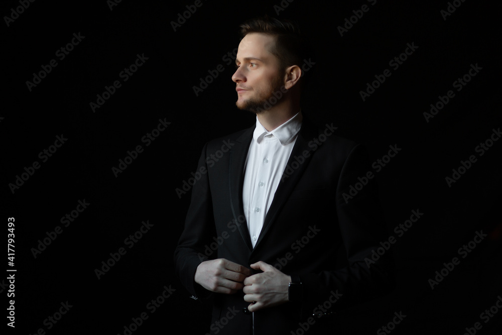 The man fastens the buttons on the black suit. Morning of the businessman. The man fastens the buttons on the black suit. Morning of the businessman.