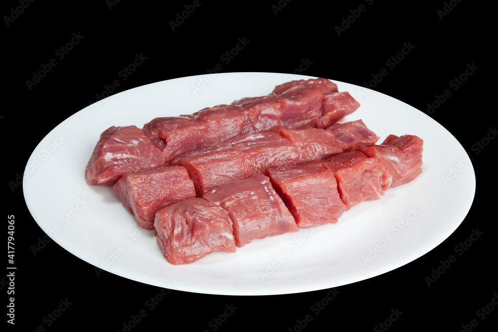 Pieces of raw meat  on a white plate