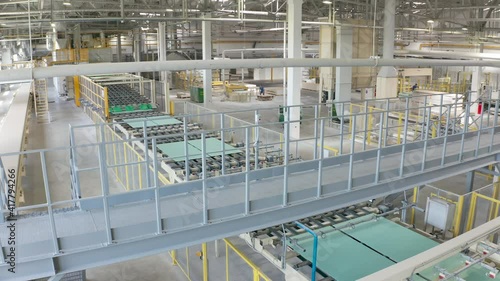 Manufacture of drywall or gypsum board by conveyor on factory. Production of building materials or plasterboard sheet