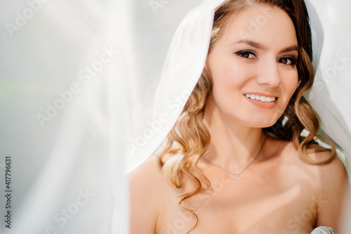 beautiful bride with long curls under the veil. delicate female portrait.