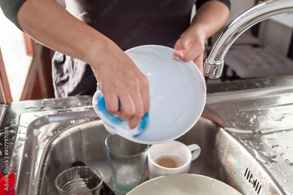 A woman washing dishes in the kitchen