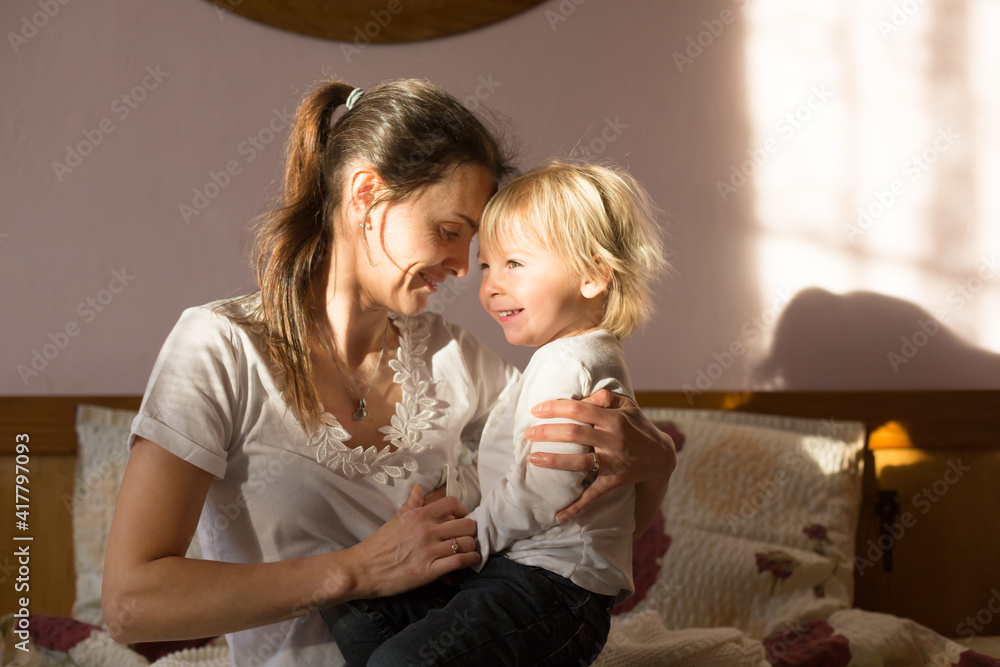 Mom and child, having fun together, reading book and eating croissant Mom and child, having fun together, reading book and eating croissant