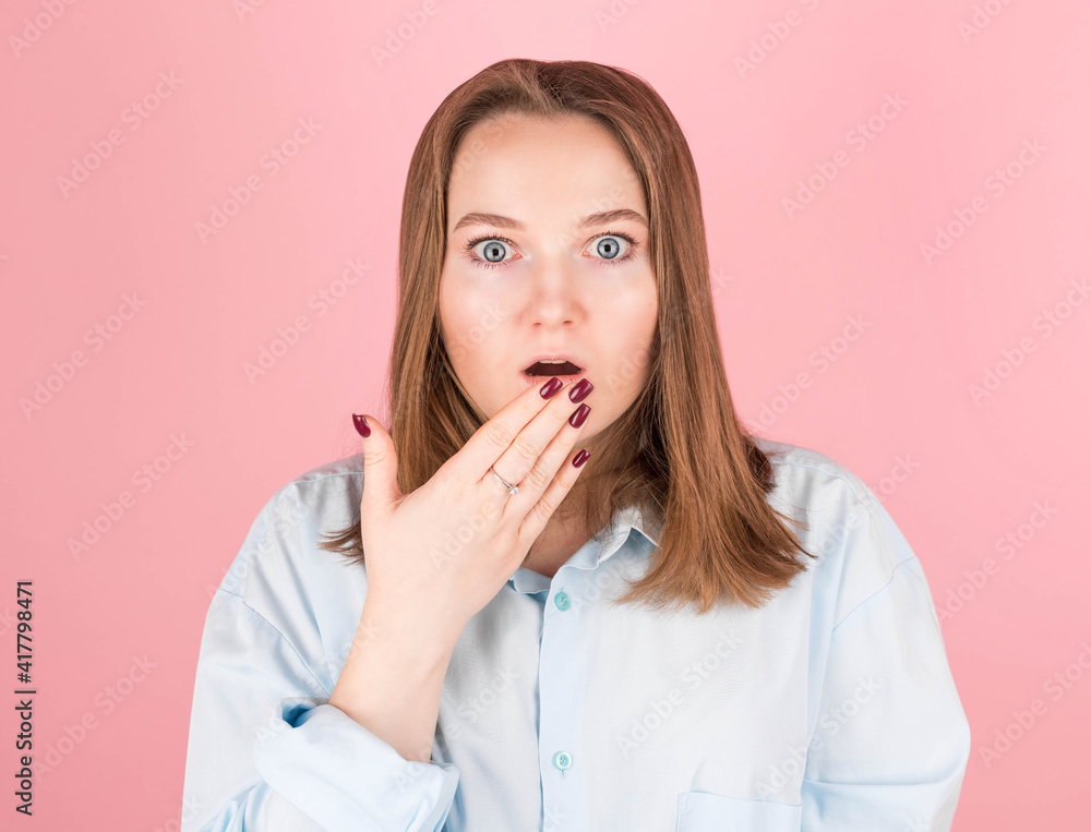 woman on pink background in blue shirt doing oops gesture woman on pink background in blue shirt doing oops gesture