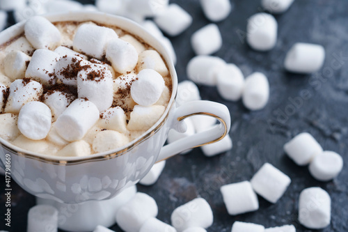 a cup of coffee on a dark table with marshmallows, scattered marshmallows, sweet coffee, cappuccino, latte