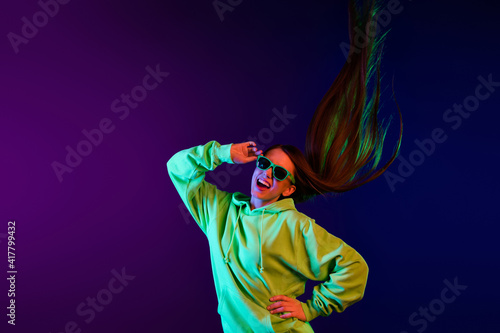 Photo of charming brunette happy woman hold hand waist wear sunglass fly hair isolated on bright neon background © deagreez