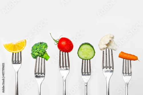 Fruit and vegetable of silver forks against a white background concept for healthy eating, dieting and antioxidant