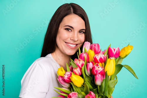 Photo of cheerful young girl happy positive smile woman day flower bouquet tulips isolated over turquoise color background