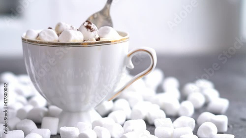 a cup of coffee on a dark table with marshmallows, scattered marshmallows, sweet coffee, cappuccino, latte