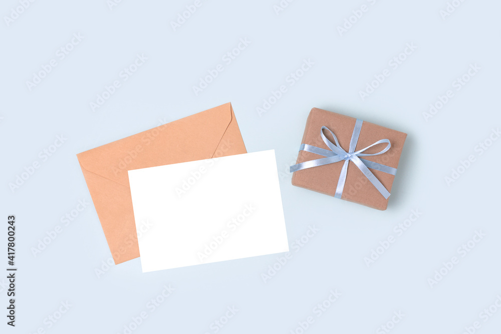 Envelope, empty paper card mockup and gift box on a blue pastel background. Present and letter for Fathers Day. Envelope, empty paper card mockup and gift box on a blue pastel background. Present and letter for Fathers Day.