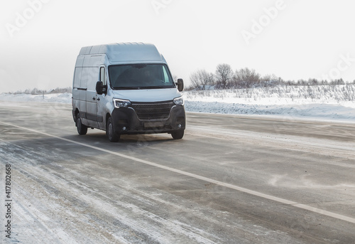 Minivan moves in winter on snow-covered road