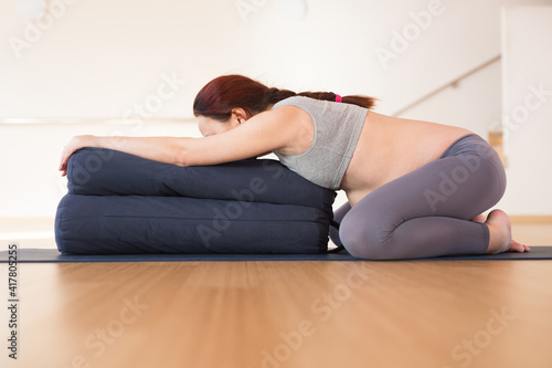 Pregnant woman is engaged in yoga. Wide Legged Child Pose or Balasana