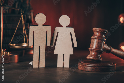 Wooden figures of people and gavel on a table close-up. Family law concept.