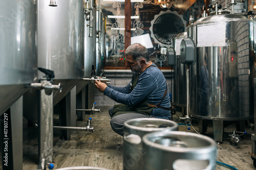 brewer working in his mini craft brewery