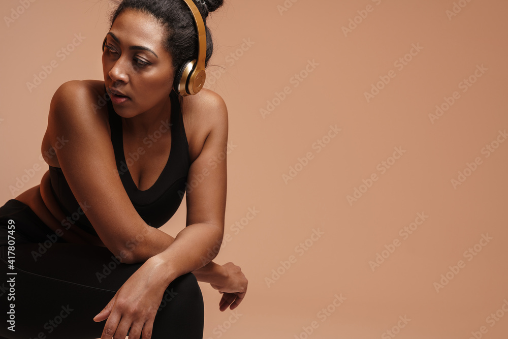 Fototapeta premium Focused african american woman doing exercise while working out