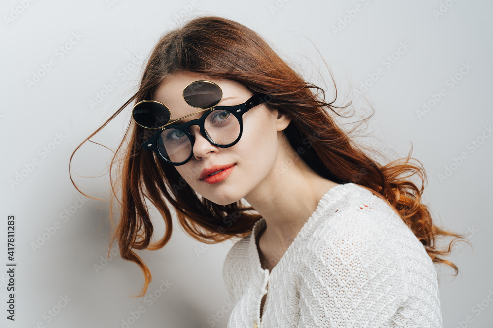 Fototapeta premium red-haired woman wearing fashion glasses red lips glamor isolated background
