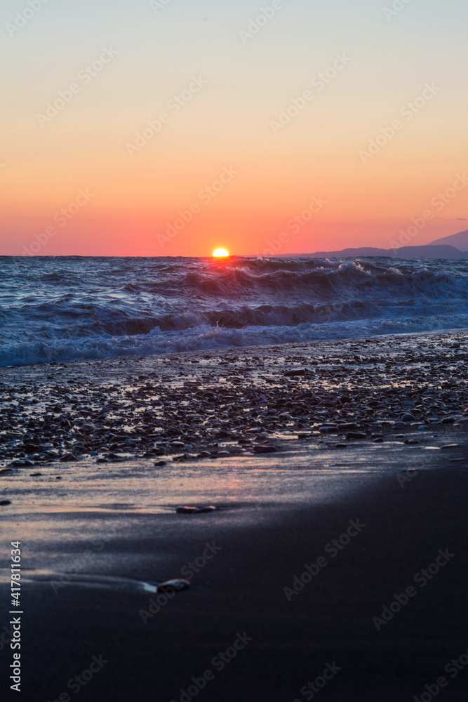 beautiful sunset by the sea with strong waves