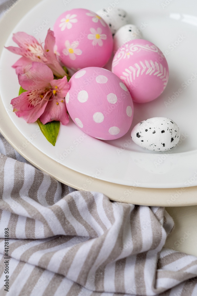 Easter menu. Holiday meal. Festive food art. Pink white painted egg with polka dot modern floral ornament decorated with flower served in plate on striped tablecloth.