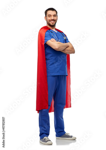 healthcare, profession and medicine concept - happy smiling doctor or male nurse in blue uniform and red superhero cape over white background