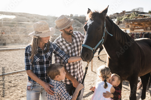 Happy family with horse having fun at farm ranch - Main focus on right boy face