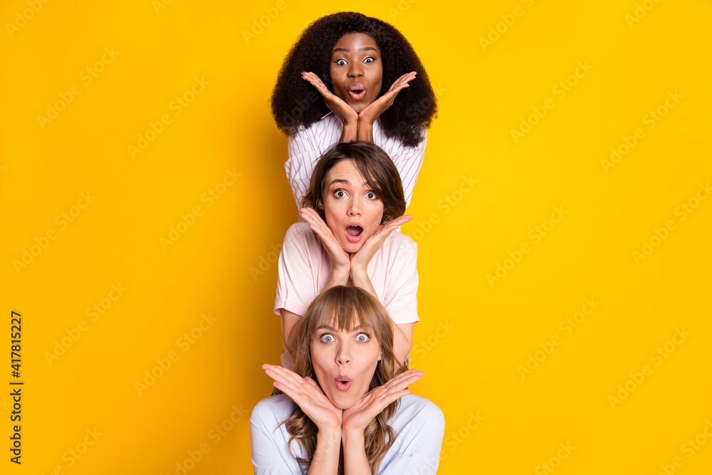 Photo of three impressed nice persons hands palms under face open mouth staring isolated on yellow color background