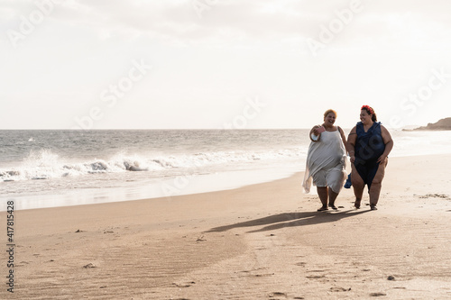 Curvy women friends taking selfie on the beach during coronavirus outbreak - Focus on faces