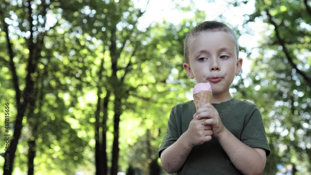 Cute Toddler boy Eating Ice-Cream. Kid with dirty face eating ice cream in the park on a warm sunny summer day Cute Toddler boy Eating Ice-Cream. Kid with dirty face eating ice cream in the park on a warm sunny summer day