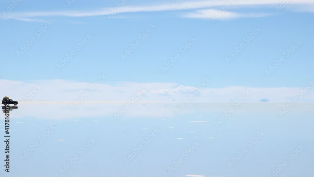 Panorama of Uyuni Salt Flats in Bolivia. Salt flat desert is covered by water in wet season. Reflections of cars and mountains at big distance. Panorama of Uyuni Salt Flats in Bolivia. Salt flat desert is covered by water in wet season. Reflections of cars and mountains at big distance.