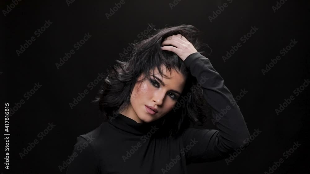 beautiful girl looking at camera in studio, close up. Curly hair fashion model with dark make-up posing on black background. beautiful girl looking at camera in studio, close up. Curly hair fashion model with dark make-up posing on black background.