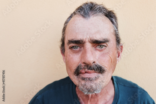 Portrait of senior man looking at camera with yellow background - Focus on face photo