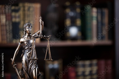 Law concept. Lawyer office. Themis statue on the shelf with legal books background. 