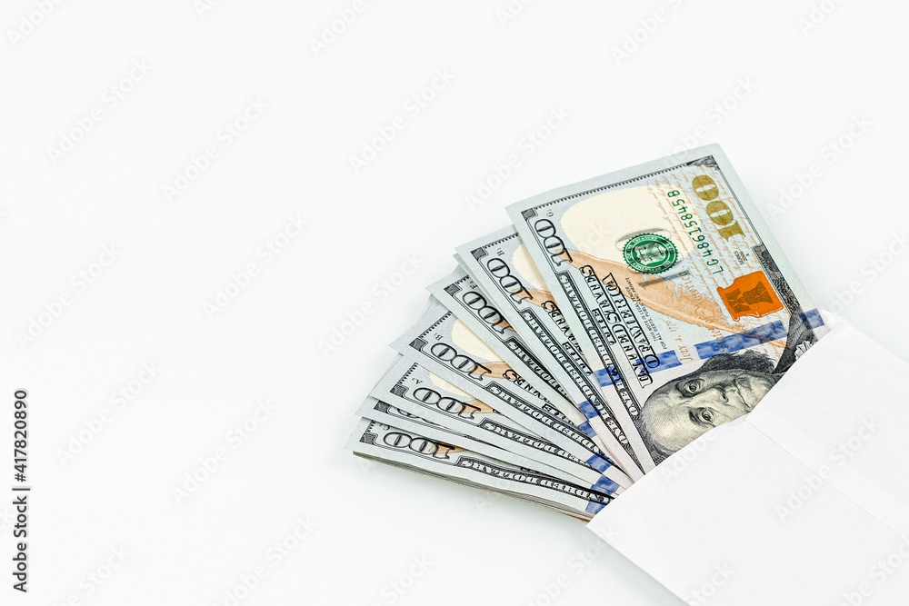 US dollars in a white envelope isolated on a white background. Concept of income bonuses or bribes. Corruption and envelope wages concept US dollars in a white envelope isolated on a white background. Concept of income bonuses or bribes. Corruption and envelope wages concept