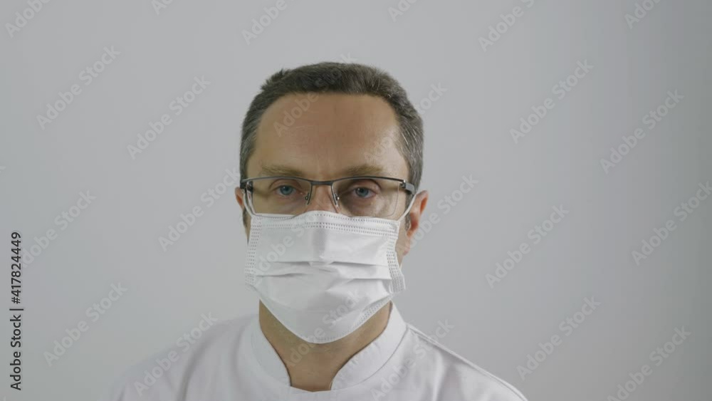 Portrait oh man doctor put on and take off protective mask to breath Portrait oh man doctor put on and take off protective mask to breath
