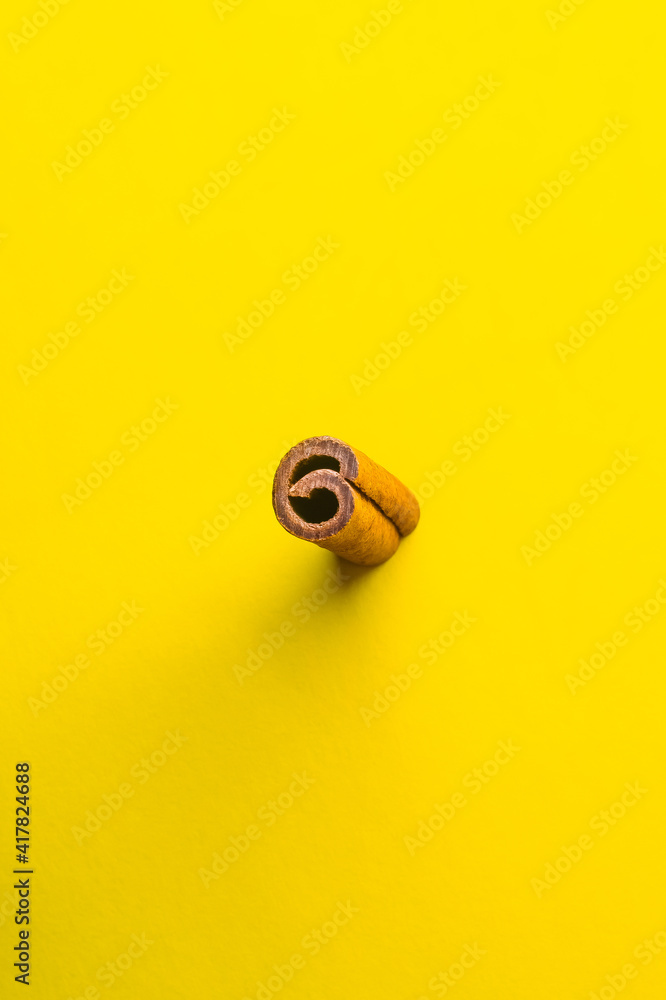 Number six shaped cross section of cinnamon stick on yellow background Number six shaped cross section of cinnamon stick on yellow background