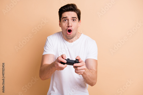 Photo of impressed young guy gamer open mouth yelling excited game isolated on beige color background