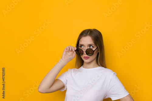 Casual Young Woman Is Looking Away Over Sunglasses