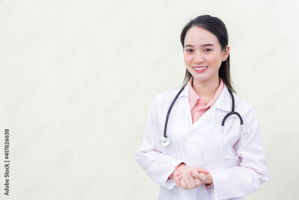 A young beautiful Asian woman doctor in a medical uniform is standing smiling Holding hands with white background. New normal and healthcare concept A young beautiful Asian woman doctor in a medical uniform is standing smiling Holding hands with white background. New normal and healthcare concept