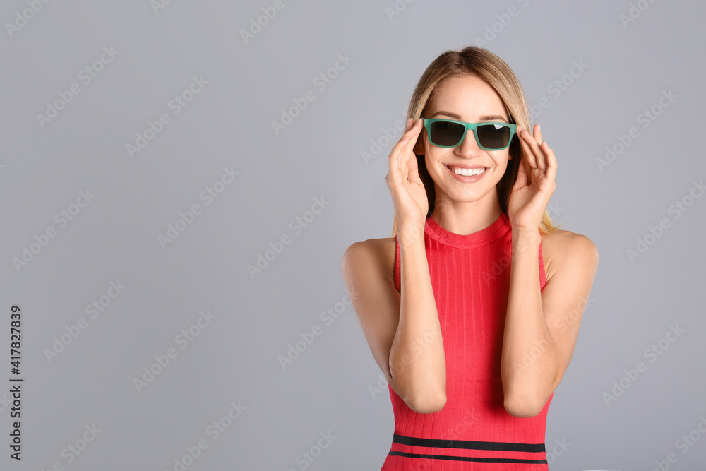 Beautiful woman in stylish sunglasses on grey background. Space for text Beautiful woman in stylish sunglasses on grey background. Space for text