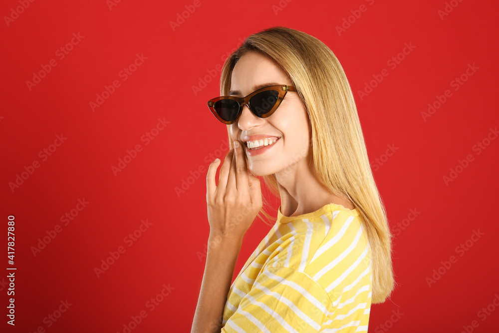Beautiful woman in stylish sunglasses on red background. Space for text Beautiful woman in stylish sunglasses on red background. Space for text