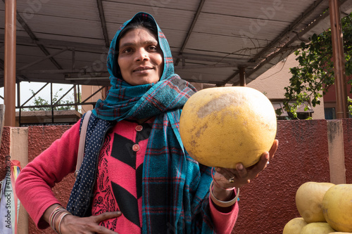 An Indian woman rejoices in a rich citrus harvest.  Traditional fruit market in India