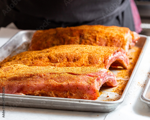 Chef puts spices on the raw piece of meat photo