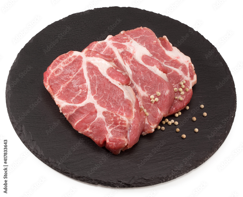 sliced raw pork meat with peppercorn on black round stone plate isolated on white background. Clipping path and full depth of field sliced raw pork meat with peppercorn on black round stone plate isolated on white background. Clipping path and full depth of field
