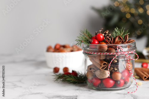 Aromatic potpourri in glass jar on white table. Space for text