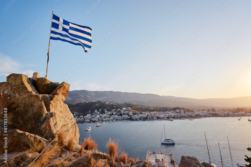 Naklejka premium Greek national flag with the sea view. Saronic gulf, Greece, Europe.