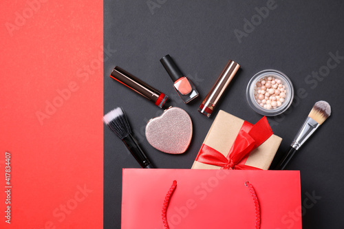 Flat lay composition with makeup products and gift box on color background