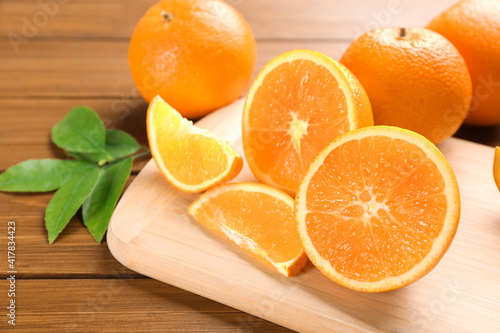 Delicious ripe oranges on wooden board  closeup