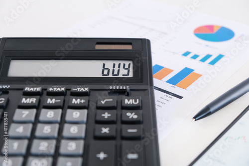 Calculator Showing Buy on Screen. Financial Advisor Concept.