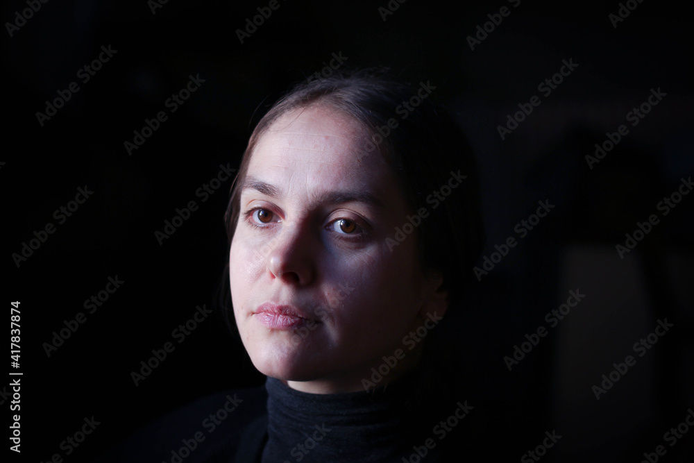 Portrait of a girl surrounded by a dark background Portrait of a girl surrounded by a dark background