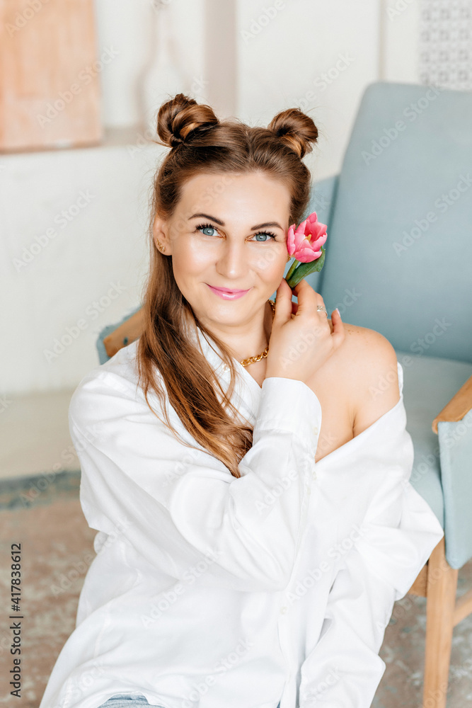 Portrait of a young beautiful girl with natural makeup, holding a flower in her hands Portrait of a young beautiful girl with natural makeup, holding a flower in her hands