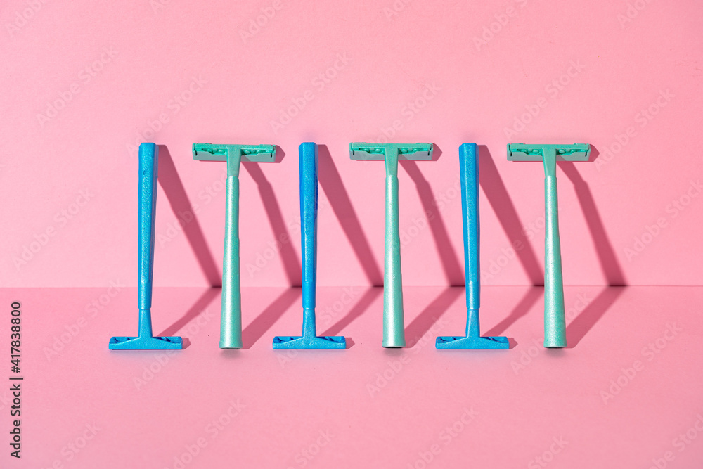 Female disposable razors on pink background, studio shot