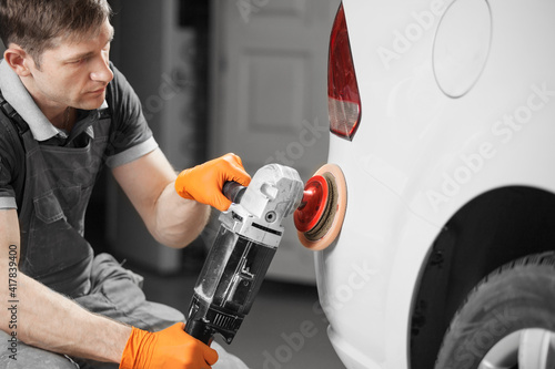 Car polishing in auto repair shop, close-up image.